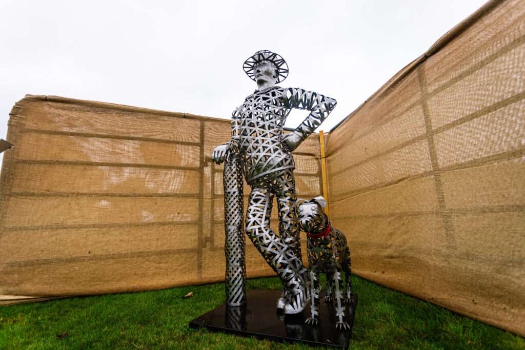 Metal sculpture of a man and dog