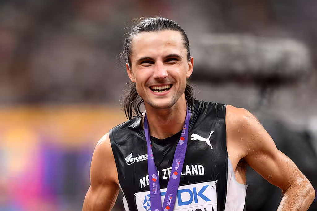 Geordie Beamish on a running track with a gold medal around his neck